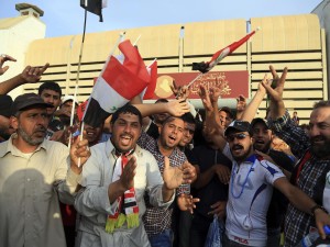 Supporters of Shiite cleric Muqtada al-Sadr raise the Iraqi flags outside parliament in Baghdad's Green Zone on Saturday. Protesters climbed over the blast walls and stormed the Parliament building.